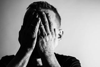 Man with his hands over his face