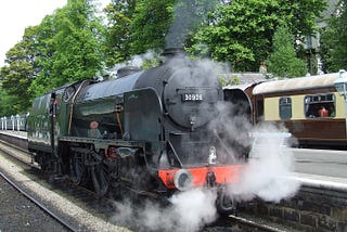 Image of a steam locomotive ‘Repton’, number 30926, as it belches out smoke idling in the platform at Grosmont railway station on the North Yorkshire Moors Railway