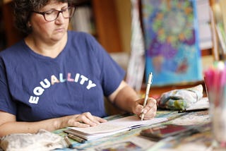 Minette in her studio, writing in her journal