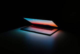 A closing laptop lid with ominous lighting.