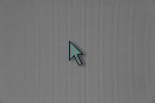 A close up photo of a computer screen with a classic mouse pointer.