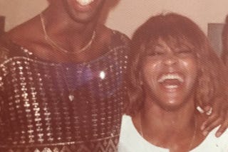 Christian Holder and Tina Turner smiling with arms wrapped around each other