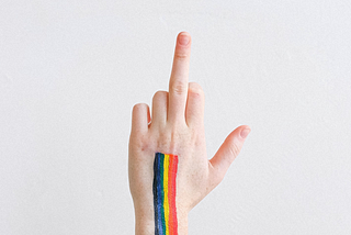 A hand giving the middle finger with rainbow paint running down it. (Image credit: Anna Shvets on Pexels)
