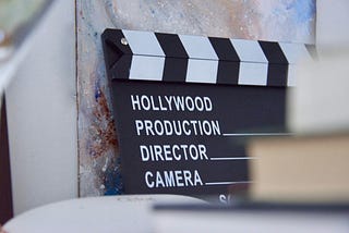 A clapperboard that has the words Hollywood Production, Director and Camera written on it.