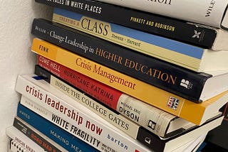 A stack of books including crisis leadership now, inside the college gates, crisis management, and more.