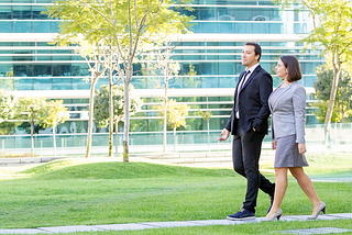 Man and woman walking outside, having a walk and talk meeting