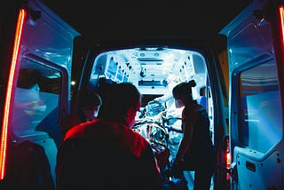 The inside of an ambulance with three paramedics and medical equipment.