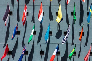 Image of assorted colored flags on a wall during day time