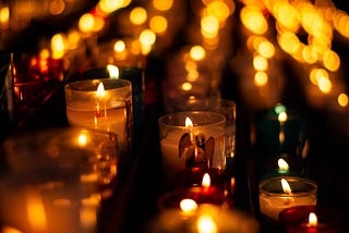 An altar of candles. An Angel is printed on the small glass candle holders.