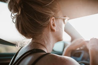Woman in sunglasses driving in a hot car