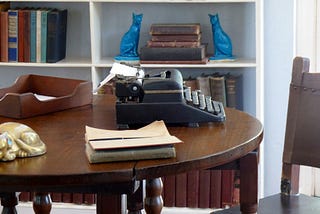 A writing desk with a typewriter on it