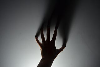 The silhouette of a hand reaching out.