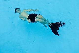 distorted image of a man underwater in a swimming pool