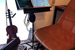 Empty chair in a practice room with violin and accordion