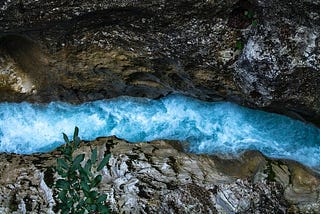 Overhead view of turbulent water running through a channel in bedrock.