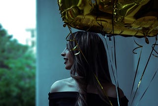 Girl holding balloons and smiling
