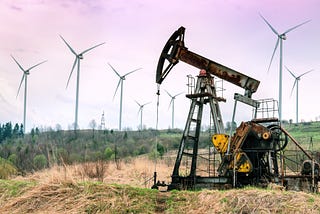 A rusting oil rig in a field. In the background, lots of energy-generating windmills. Represents the transition from fossil fuels to renewable energy sources.