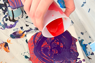 Paint Pouring with acrylic paint on ceramic tile.