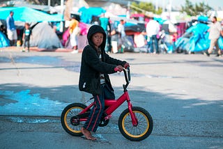 a young immigrant boy on a bike
