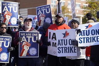 Several ATU members holding signs that say “We are one ATU” and “ATU on strike.”