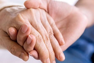 Zdjęcie w artykule — dodatek pielęgnacyjny a zasiłek pielęgnacyjny, ukazane 2 splecione dłonie w geście opiekuńczym