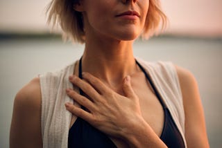 Woman with her eyes closed and hand hand on her heart at peace