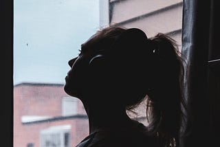 Silhouette Photo of a Woman Looking Through Window