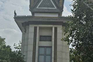 Choeung Ek Genocidal Center memorial. white concrete with a pagoda style roof.