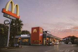 McDonald’s chain restarant sits in photo’s distance while the sun sets, creating a cotton candy sky.