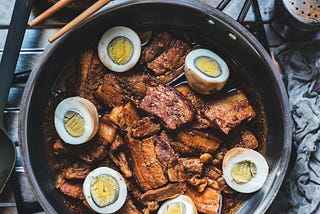 Filipino Food Pork Adobo with hard-boiled eggs in a pan.