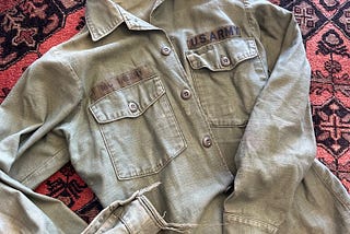 Picture of a tattered Army jacket with the name McInerny printed over a breast pocket