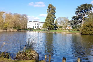 A lake with a white building in the foreground depicting a good season in life