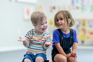 Two young kids sitting and talking