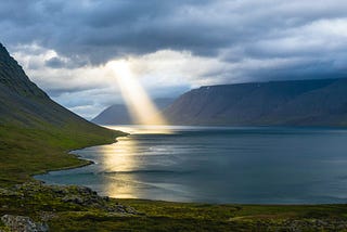 Mountain lake vista with sunbeam.