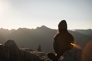 Woman sitting on a mountain during the day