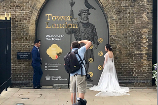 A couple posing outside the gates of Tower of London.