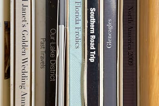 A close-up of the on the spines of Apple Photo Books showing titles like “Southern Road Trip” and “Ian and Janet’s Golden Wedding Anniversary”.