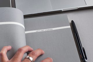 a blank notebook page with text written“let’s get started”