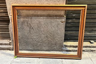 An empty picture frame on the side of the street.