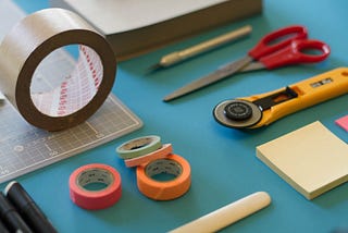 A mix of stationery and office supplies on a blue background.