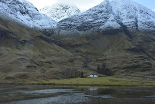 Scotland’s mountains and valleys, with a small cottage in the wilderness