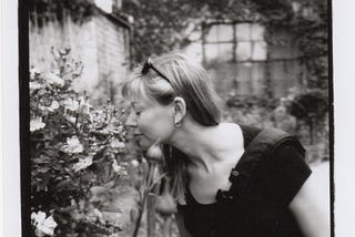 The author, Julie Lindow, smelling a rose in Claude Monet’s garden.