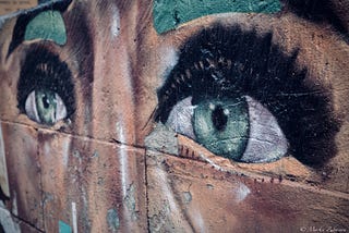 A graffiti on a wall: the upper part of a human face, eyes and eyebrows.