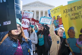 Pro-choice women holding signs in front of the Supreme Court building.