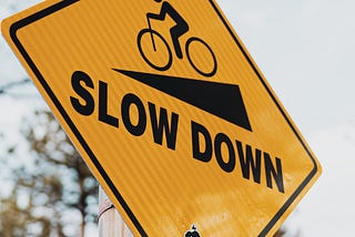 image of sign to slow down on a steep hill