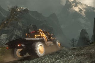 A yellow utility vehicle drives towards the mountains in the Xbox 360 version of Halo: Reach.