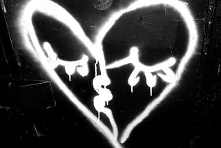 Graffiti heart with eyes looking quite sad plus figure 52 in corner — black and white