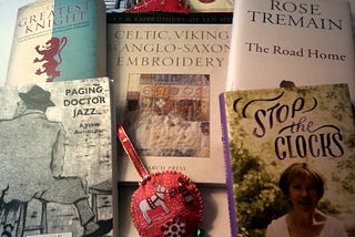 Image of 5 Books spread out with a Christmas decoration above and below made from textile material in red to hang from a tree