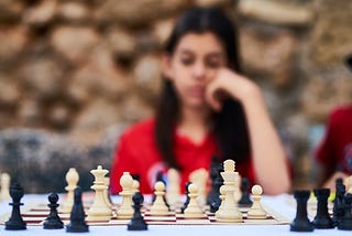 A woman plotting her next move in chess.