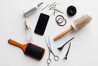 Hair tools including a brush, hairspray, ties, scissors and clips